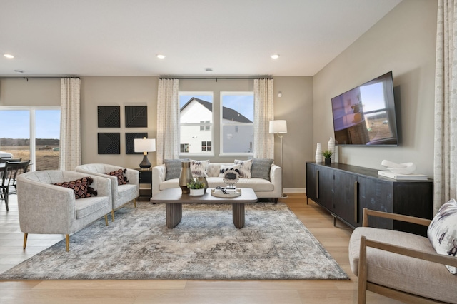 living area featuring light wood finished floors, baseboards, and recessed lighting