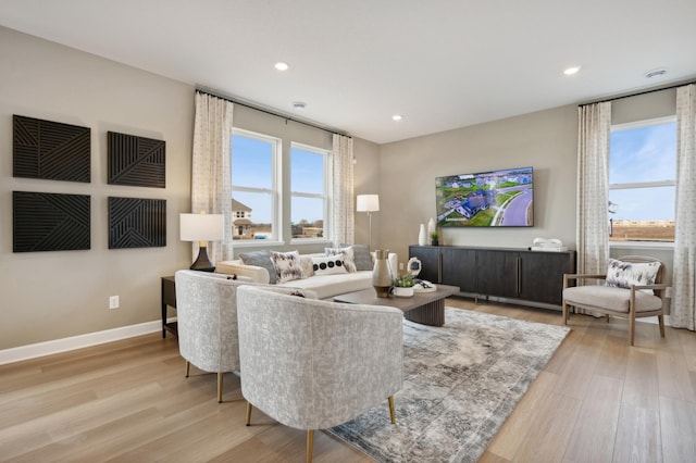 living area featuring light wood-style floors, baseboards, and recessed lighting