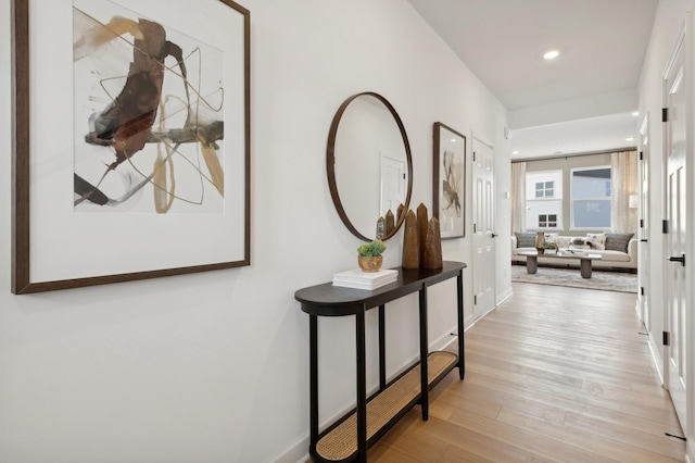 hall with light wood-style floors, baseboards, and recessed lighting