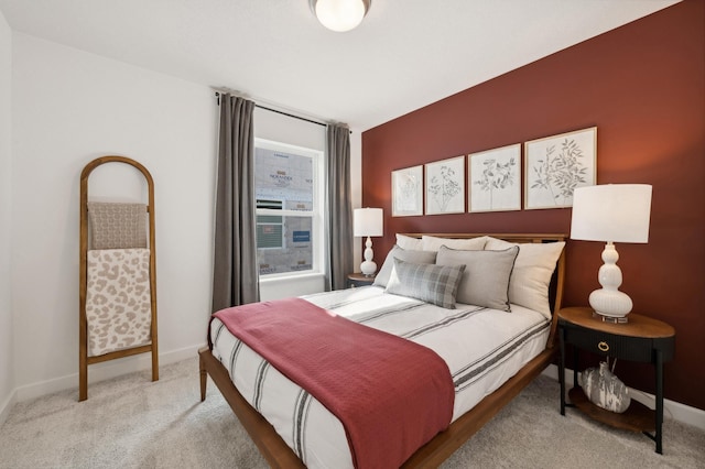 bedroom with light colored carpet and baseboards