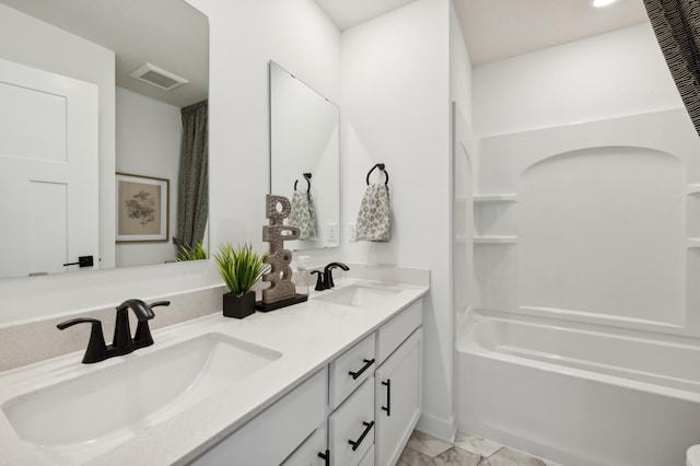 full bathroom featuring marble finish floor, double vanity, a sink, and visible vents