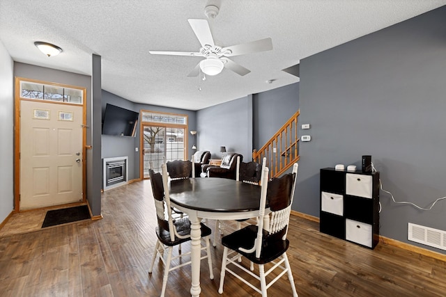 dining space featuring ceiling fan, wood-type flooring, and a textured ceiling