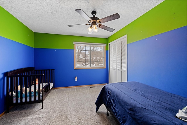 bedroom featuring ceiling fan, carpet floors, a textured ceiling, and a closet