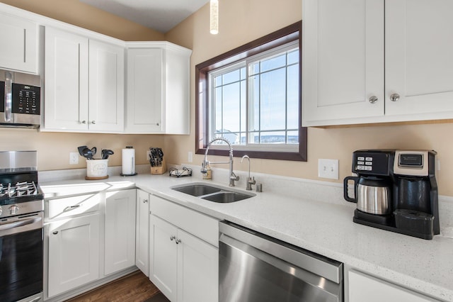 kitchen featuring stainless steel appliances, light stone countertops, white cabinets, sink, and dark hardwood / wood-style floors