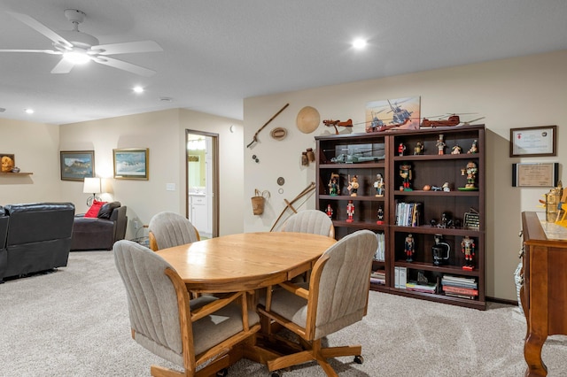 dining room with ceiling fan and light colored carpet