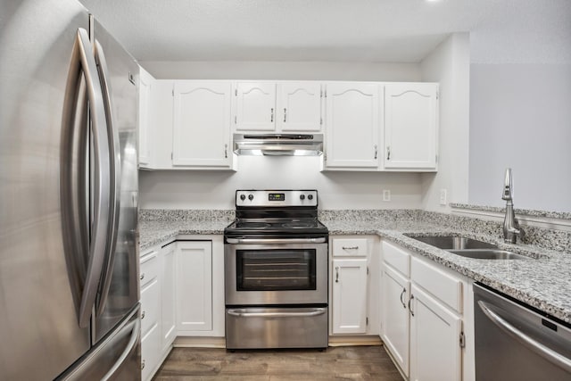 kitchen featuring appliances with stainless steel finishes, white cabinetry, a sink, and under cabinet range hood