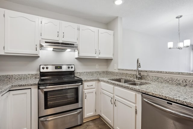 kitchen featuring white cabinets, stainless steel appliances, under cabinet range hood, pendant lighting, and a sink