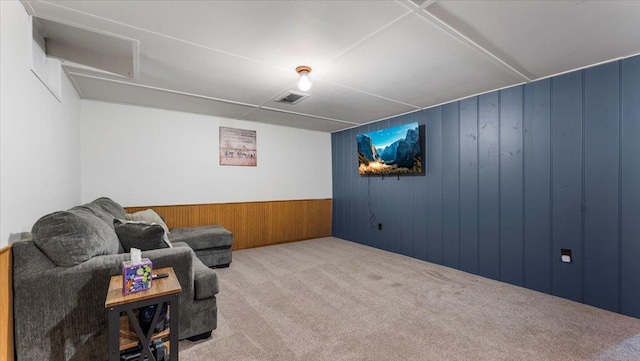 living area with wooden walls and carpet