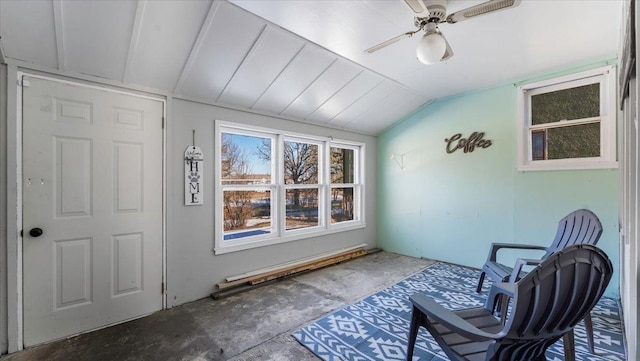 sitting room with ceiling fan, vaulted ceiling, and concrete floors