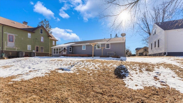 snow covered house featuring central AC unit