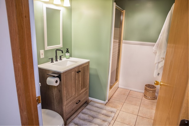 bathroom with walk in shower, vanity, and tile patterned flooring