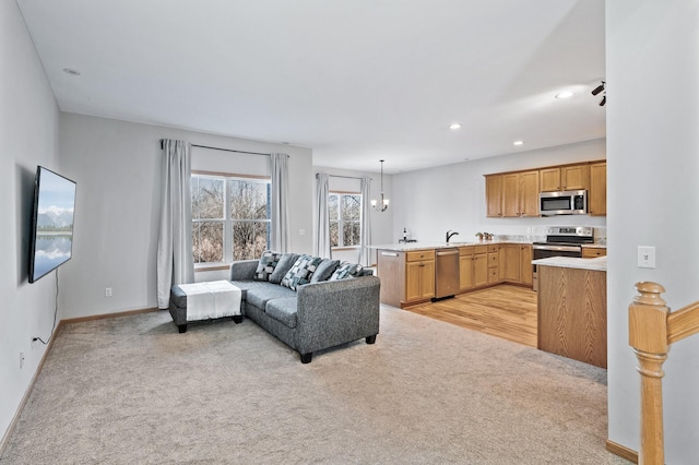 living area featuring baseboards, recessed lighting, an inviting chandelier, and light colored carpet