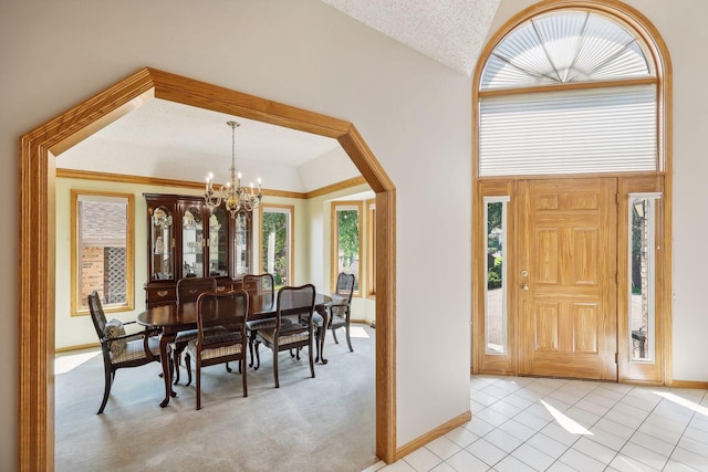 tiled foyer featuring a notable chandelier and vaulted ceiling