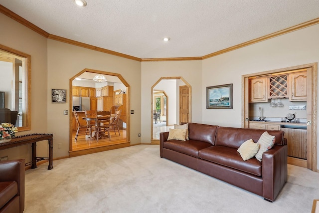 carpeted living room featuring crown molding, radiator, wet bar, and a textured ceiling