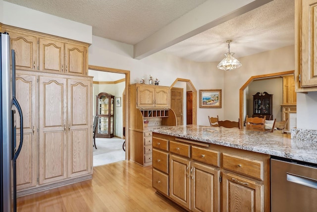 kitchen with decorative light fixtures, a textured ceiling, light wood-type flooring, appliances with stainless steel finishes, and beam ceiling