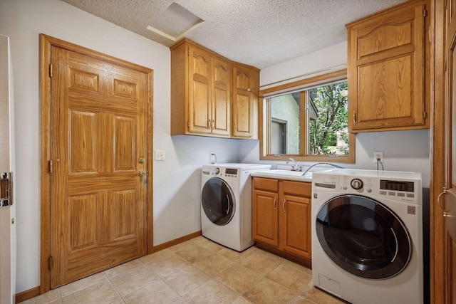 laundry room featuring washer and dryer, sink, cabinets, light tile patterned floors, and a textured ceiling