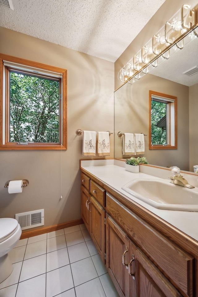 bathroom featuring vanity, tile patterned floors, toilet, and a textured ceiling