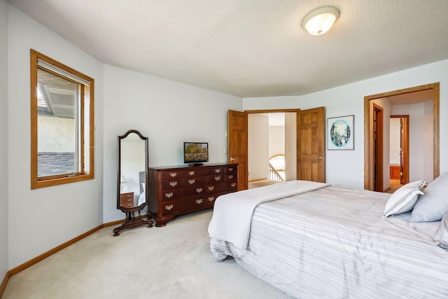 bedroom featuring light colored carpet and a textured ceiling