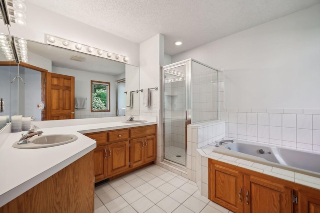 bathroom with tile patterned flooring, vanity, shower with separate bathtub, and a textured ceiling