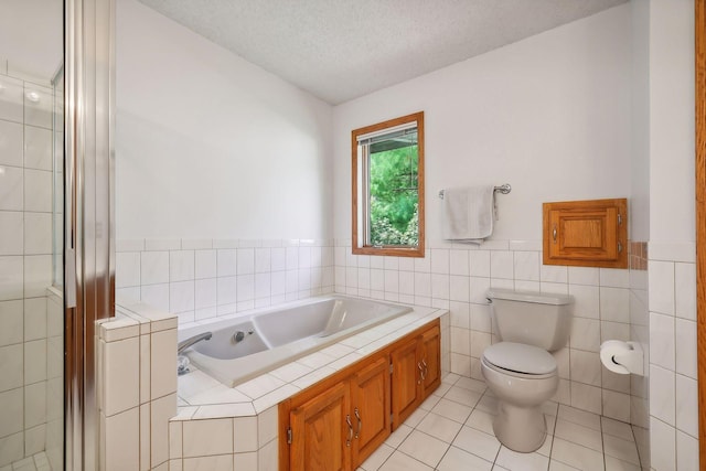 bathroom with tile patterned flooring, tile walls, separate shower and tub, a textured ceiling, and toilet