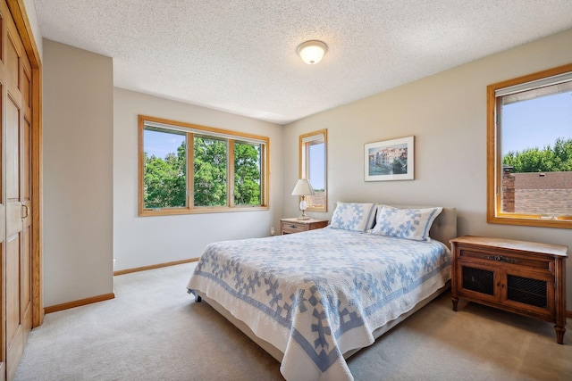 bedroom featuring light carpet and a textured ceiling