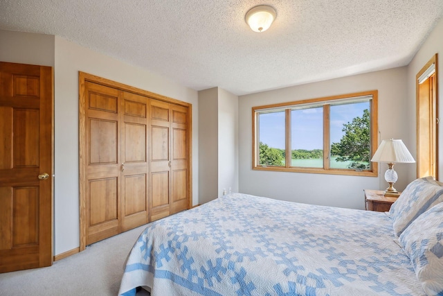 carpeted bedroom with a water view, a textured ceiling, and a closet