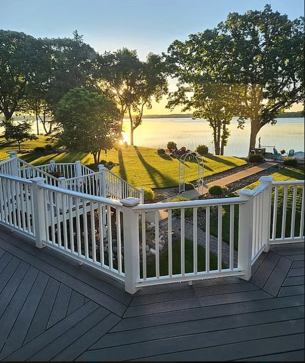 deck at dusk featuring a water view