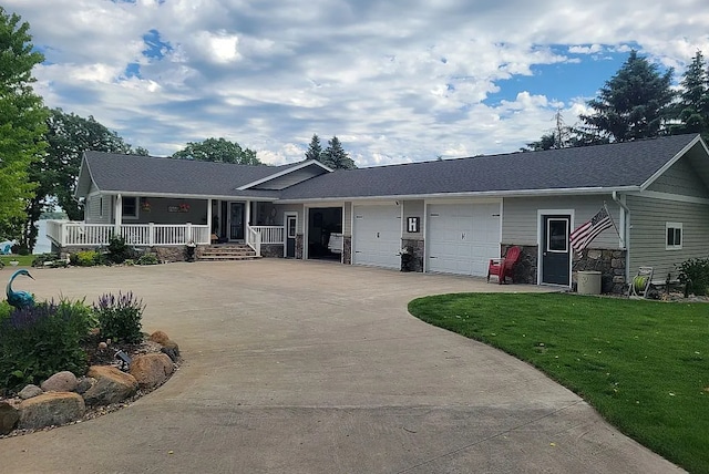 ranch-style house featuring a garage, a front yard, and covered porch