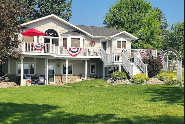 rear view of property with a wooden deck and a yard