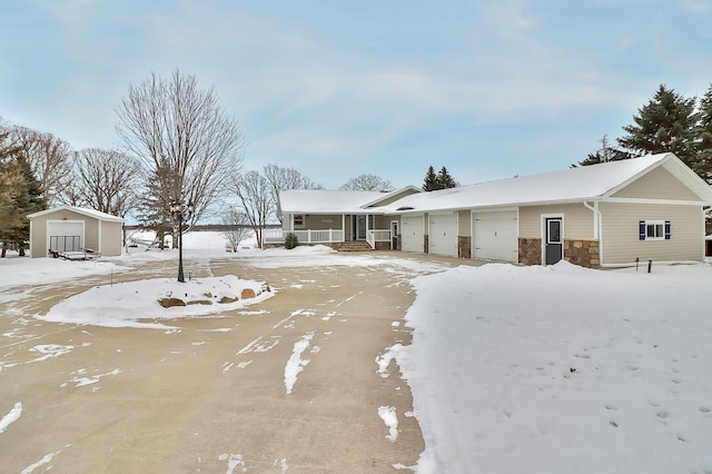 ranch-style house featuring a garage, covered porch, and a storage unit