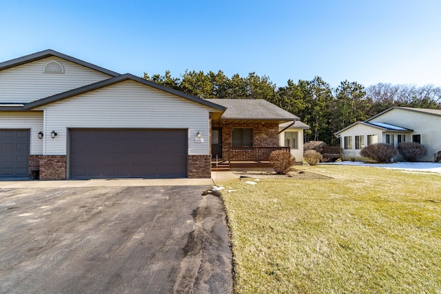 ranch-style home featuring a garage, covered porch, and a front lawn