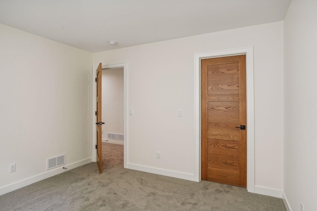 unfurnished room featuring light colored carpet