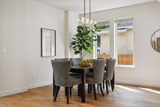 dining area featuring light hardwood / wood-style floors and a chandelier