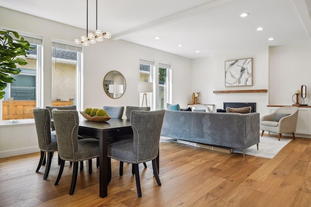 dining room with light hardwood / wood-style flooring and a notable chandelier