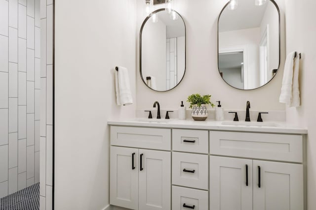 bathroom with tiled shower and vanity