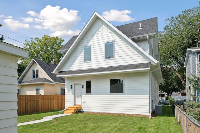 back of house with cooling unit and a lawn