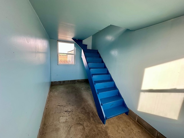 stairway with concrete flooring