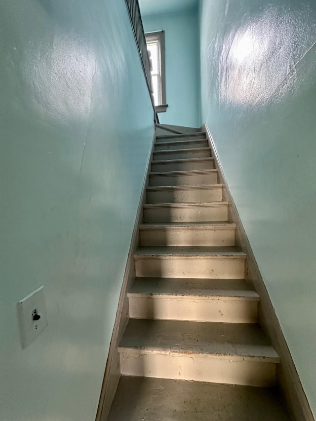 stairs with concrete flooring