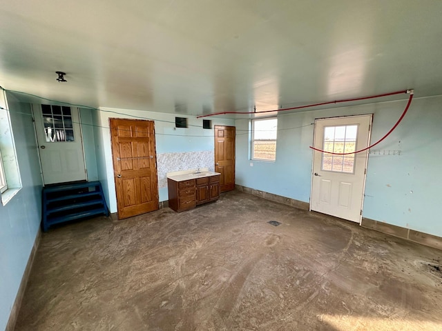 18426 County Road 18, Lewiston, MN 55952 - unfurnished living room with baseboards, a sink, and concrete flooring