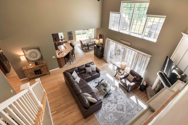 living room featuring a high ceiling and light wood-type flooring