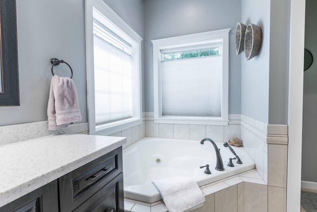 bathroom with vanity and tiled bath