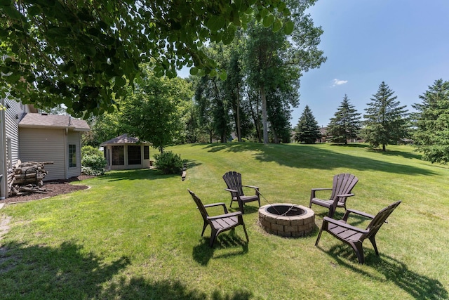 view of yard with an outdoor structure and an outdoor fire pit