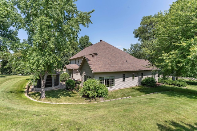 back of house featuring a sunroom and a lawn