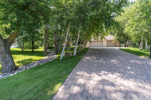 obstructed view of property featuring a garage and a front lawn