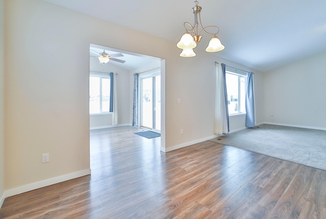 spare room featuring hardwood / wood-style flooring, lofted ceiling, and ceiling fan with notable chandelier