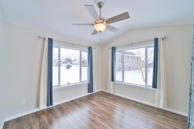 spare room with vaulted ceiling, dark wood-type flooring, and ceiling fan