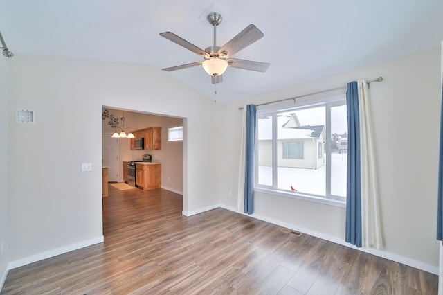 spare room featuring dark hardwood / wood-style flooring, ceiling fan with notable chandelier, and lofted ceiling