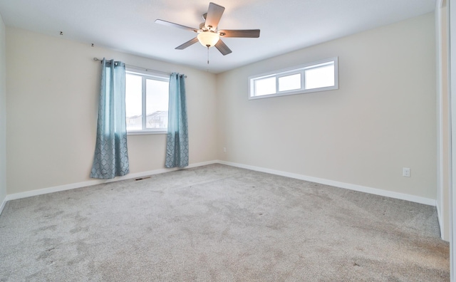 unfurnished room with plenty of natural light, carpet floors, and ceiling fan