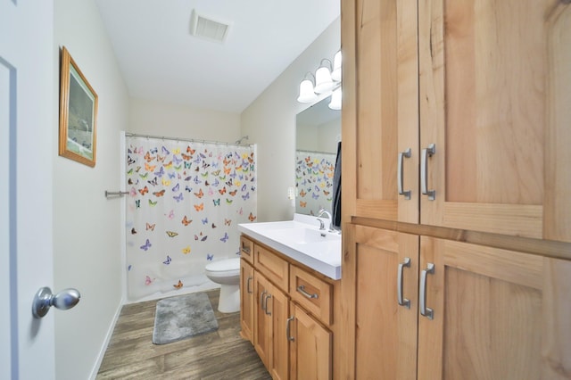 full bathroom featuring vanity, hardwood / wood-style floors, shower / tub combo, and toilet