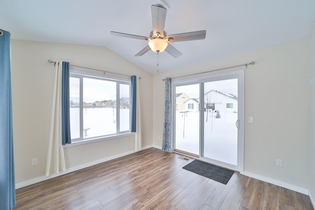unfurnished room with wood finished floors, ceiling fan, vaulted ceiling, and baseboards